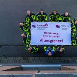Feuerwehrbeschäftigte in Münster mit Transparent "Hände weg von unserer Altersgrenze!"