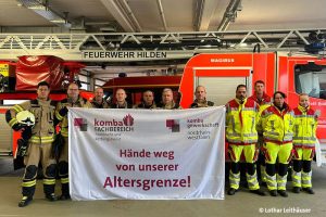 Feuerwehrbeschäftigte in Hilden mit Transparent "Hände weg von unserer Altersgrenze!"
