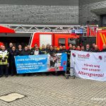 Feuerwehrbeschäftigte in Mülheim an der Ruhr mit Transparent "Hände weg von unserer Altersgrenze!"