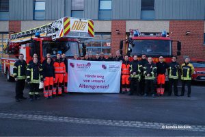 Feuerwehrbeschäftigte in Beckum mit Transparent "Hände weg von unserer Altersgrenze!"