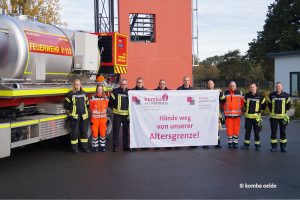 Feuerwehrbeschäftigte in Oelde mit Transparent "Hände weg von unserer Altersgrenze!"