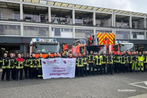 Feuerwehrbeschäftigte in Bonn mit Transparent "Hände weg von unserer Altersgrenze!"